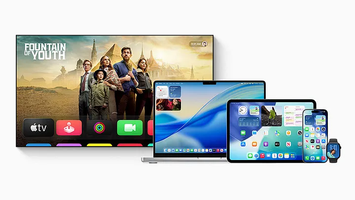 Apple TV, MacBook, iPad, iPhone and Apple Watch showing Liquid Glass interfaces